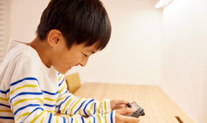 前かがみの姿勢でゲームをする子ども
