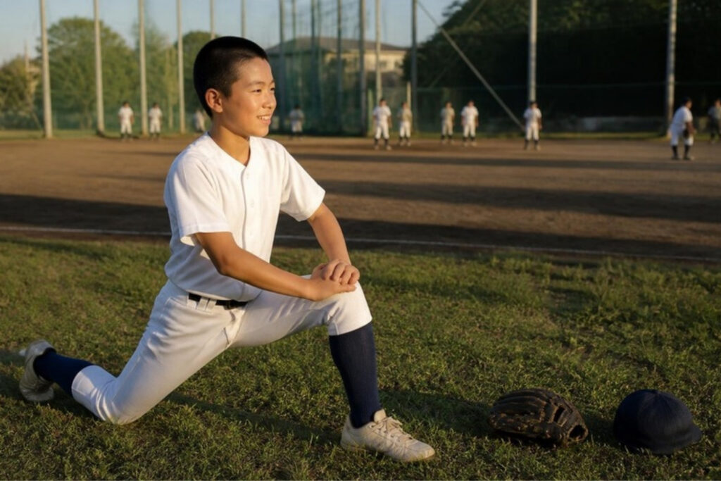 練習前にストレッチをする野球少年のイメージ